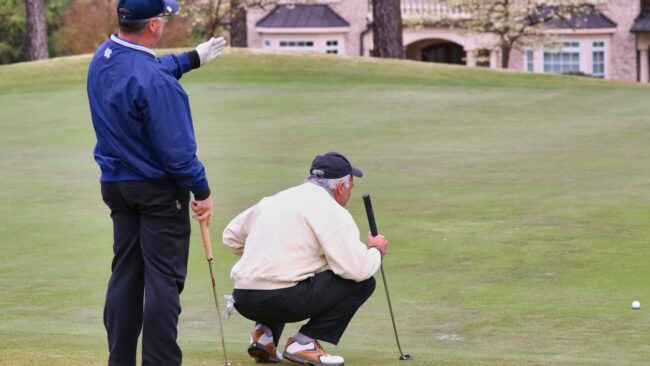 man in blue long sleeve shirt and black pants playing golf during daytime